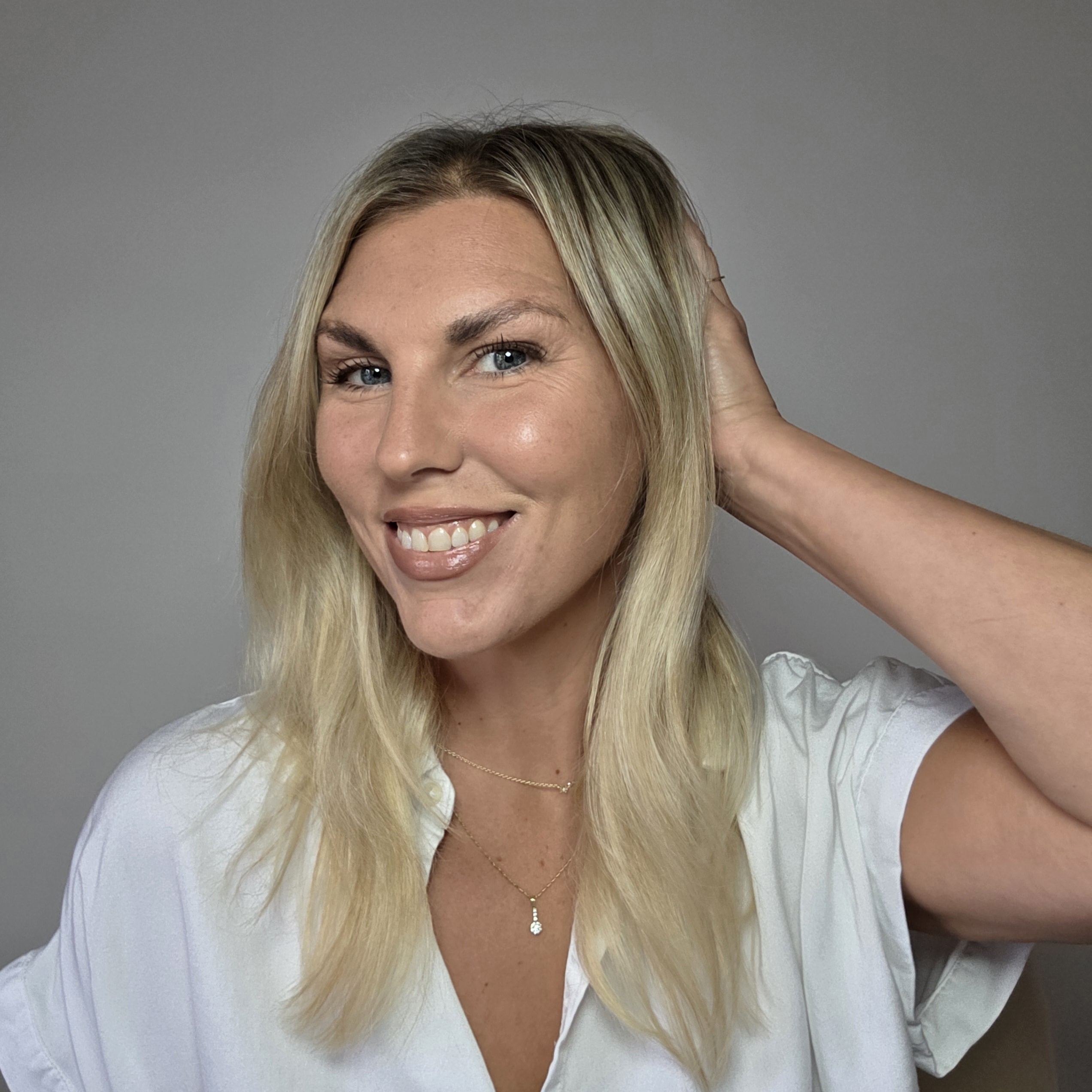 Smiling woman over 40 with long blonde hair in a white blouse