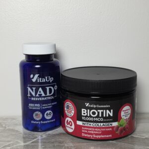 VitaUp NAD+ supplements and biotin gummies on white surface for women over 40 supporting hair health and growth from the inside out