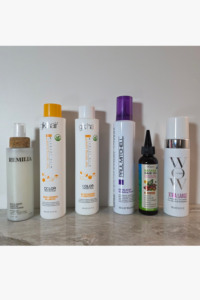 Complete minimalist hair care product collection for women over 40 with thin fine hair arranged in clean row on white background showing simplified intentional routine