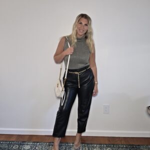 vintage gold metallic sleeveless turtleneck with thrifted black leather pants gold chain belt and white crossbody bag