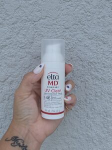 Hand holding an EltaMD UV Clear facial sunscreen tube