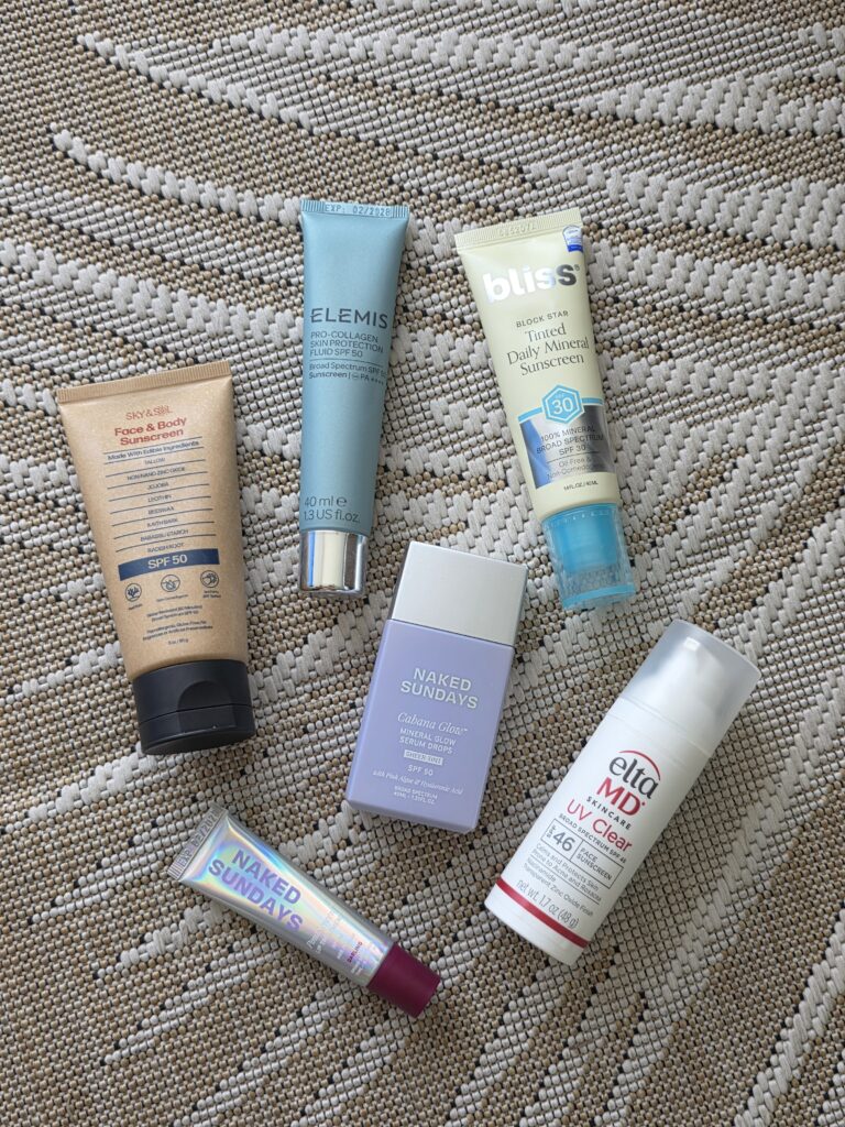 Flat lay of several mineral sunscreen tubes and bottles for mature skin
