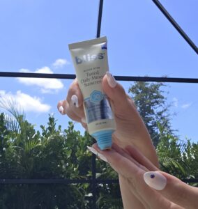 Holding a sunscreen tube up against a blue sky