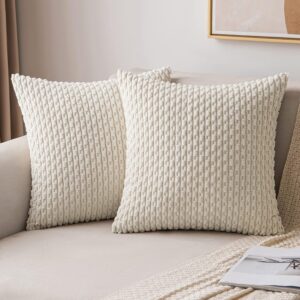 Pair of cream textured corduroy throw pillows on a neutral sofa