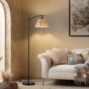 Arched floor lamp with a fluted cream shade casting warm light beside a cream sofa