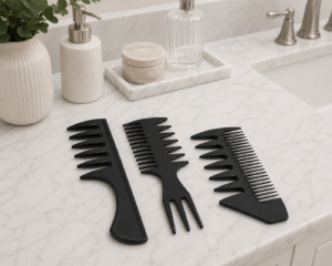 Three black wide-tooth and pick styling combs on a white marble bathroom counter
