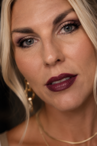 Close-up of a woman over 40 wearing a soft, diffused deep-berry lip — the heart of the vamp-romantic look