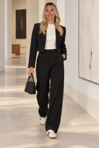 Woman over 40 wearing a casual blazer with relaxed trousers and clean sneakers