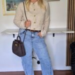 Barrel-leg jeans with a cropped cream cardigan, brown bag and clear pointed heels